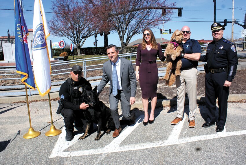 Officer Gregg Bruno with K-9 officer Zeus, Representative Magaziner, State Representative for the 17th district Jackie Bazinski, Officer Mike Iaconne, K-9 Officer Cali, and Cranston Police Chief Col. Michael Winquist stand together after the announcement of hundreds of thousands of dollars of federal funds for the vehicles for the K-9 Units. (Photo by Steve Popiel)