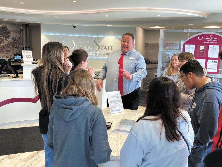 MONEY TALKS: Ocean State Credit Union Bank Manager Michael Freeman talks to students about how banks operate in the middle of their Warwick location. (Photo by Adam Zangari)