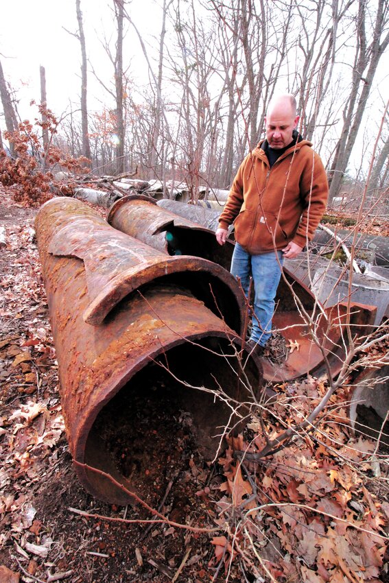 BURST PIPE: Michael DiPetrillo and a section of 30-inch cast iron pipe that carried about half of the 9 million gallons of water the city uses daily. The section of pipe ruptured in December 2018. Fortunately, there was a bypass that the city has depended on since. (Warwick Beacon file photo)