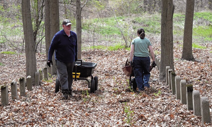 BEAUTIFYING: Wheelbarrows were essential at this spring&rsquo;s cleanups of the historic cemetery which lies in the woods behind the Rhode Island Training School. Volunteers came equipped with plenty of yard equipment to give some dignity to those buried here, a century later. (Photo by Barbara Polichetti)