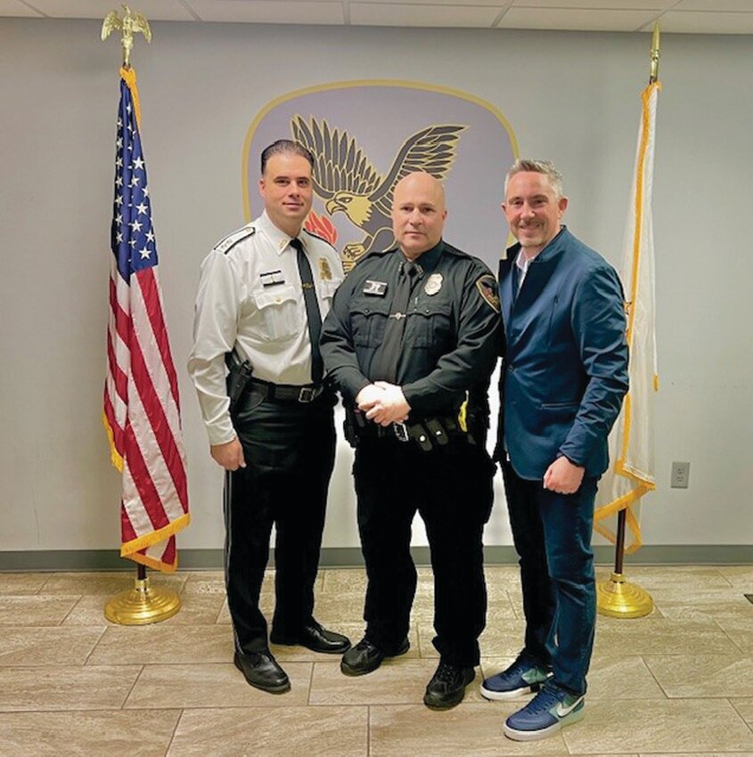 HONORED: Officer Mario Mennella of the Johnston Police Department received an Elwood Johnson Outstanding Service Award citation and pin from Special Olympics Rhode Island President and CEO Ed Pacheco during a recent department visit. Officer Mennella is one of 12 nominees for the statewide Elwood Johnson Outstanding Service Award. From left to right in the photo are: Johnston Police Chief Mark A. Vieira, Officer Mennella, and Pacheco.