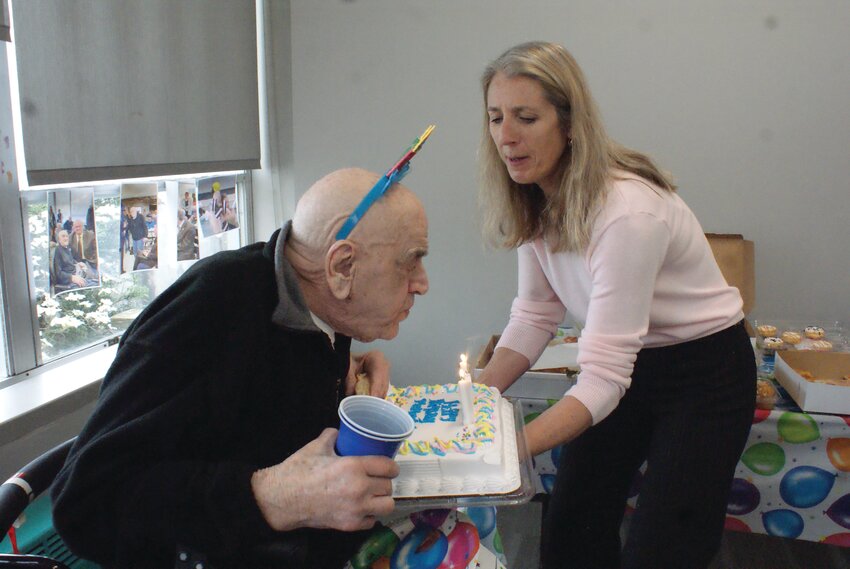 MAKE A WISH: Above, Tracey Simoneau, a Water Fitness Instructor at the Cranston YMCA, presents Frank Mancini, at right, with his birthday cake to blow out the candles. At left, the entire YMCA, and Mancini&rsquo;s family, gathered to celebrate. (Cranston Herald Photos by Steve Popiel)