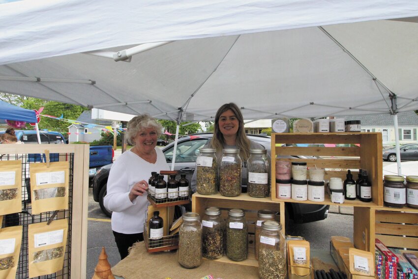 OPEN ON SATURDAYS: Leslie Derrig, president of the Conimicut Village Association and association member Barbara Camton at one of the vendor displays at the CVA Farmers Market that opened for a first time on Saturday. (Warwick Beacon photo by Carol Howell)