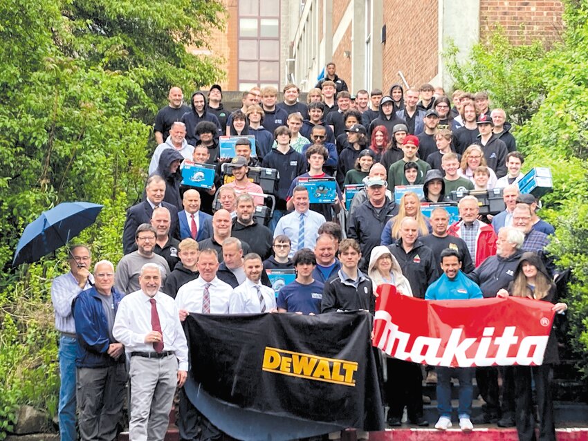 MADE IT THROUGH TOGETHER: Students from all four participating schools, as well as representatives from local construction companies, brave the rain and pose together following the ceremony.
