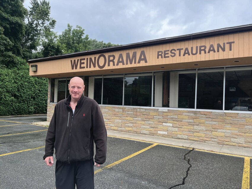 MEMORIES: Tim Wolfe of Cranston was one of many people stopping by Wein-O-Rama on Tuesday to snap a photo. The Oaklawn Avenue property is now for sale.