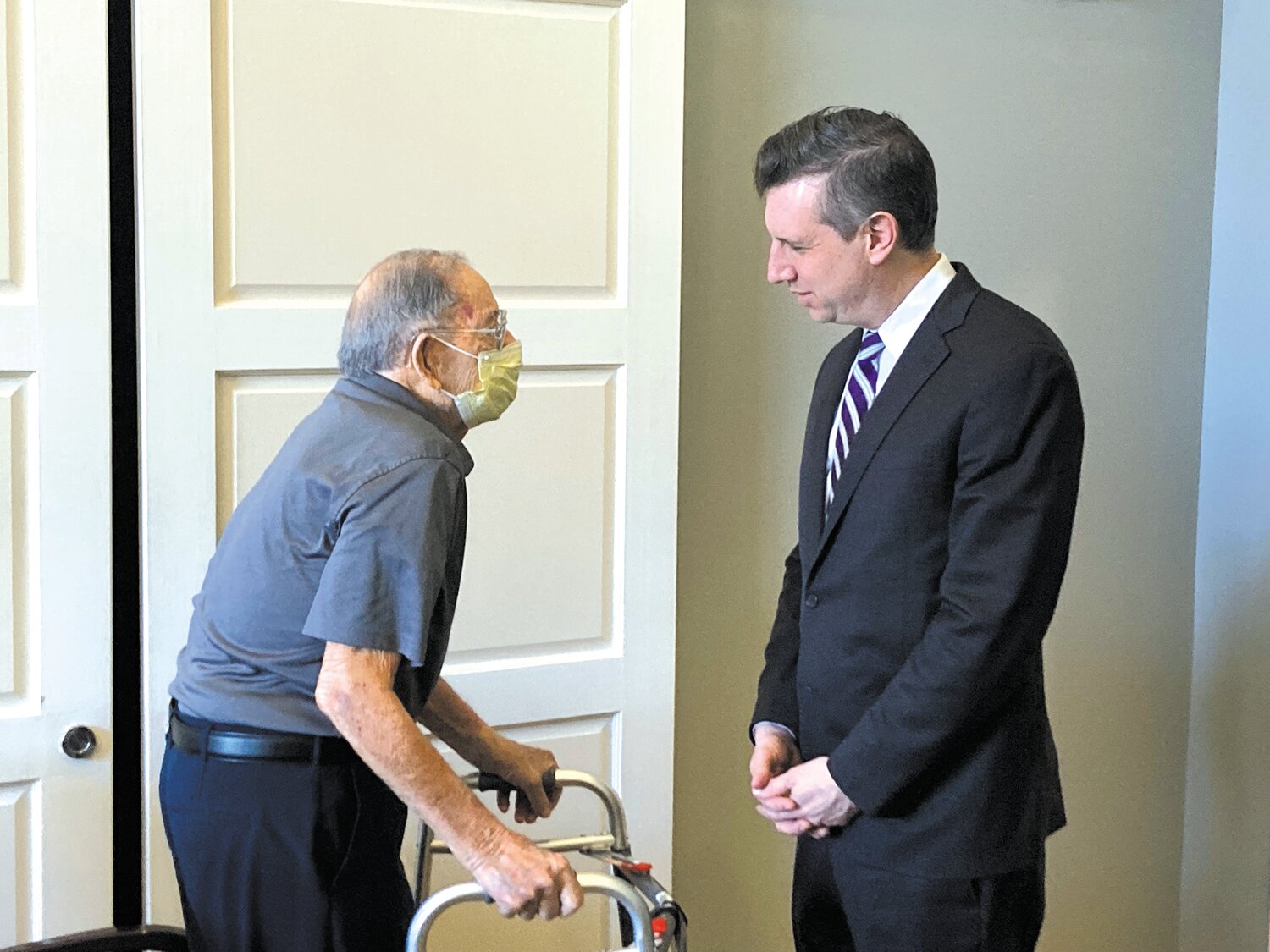 MEETING WITH ATTENDEES: Anthony Russo, a resident of Greenwich Farms, greets Magaziner as he walks into the room.