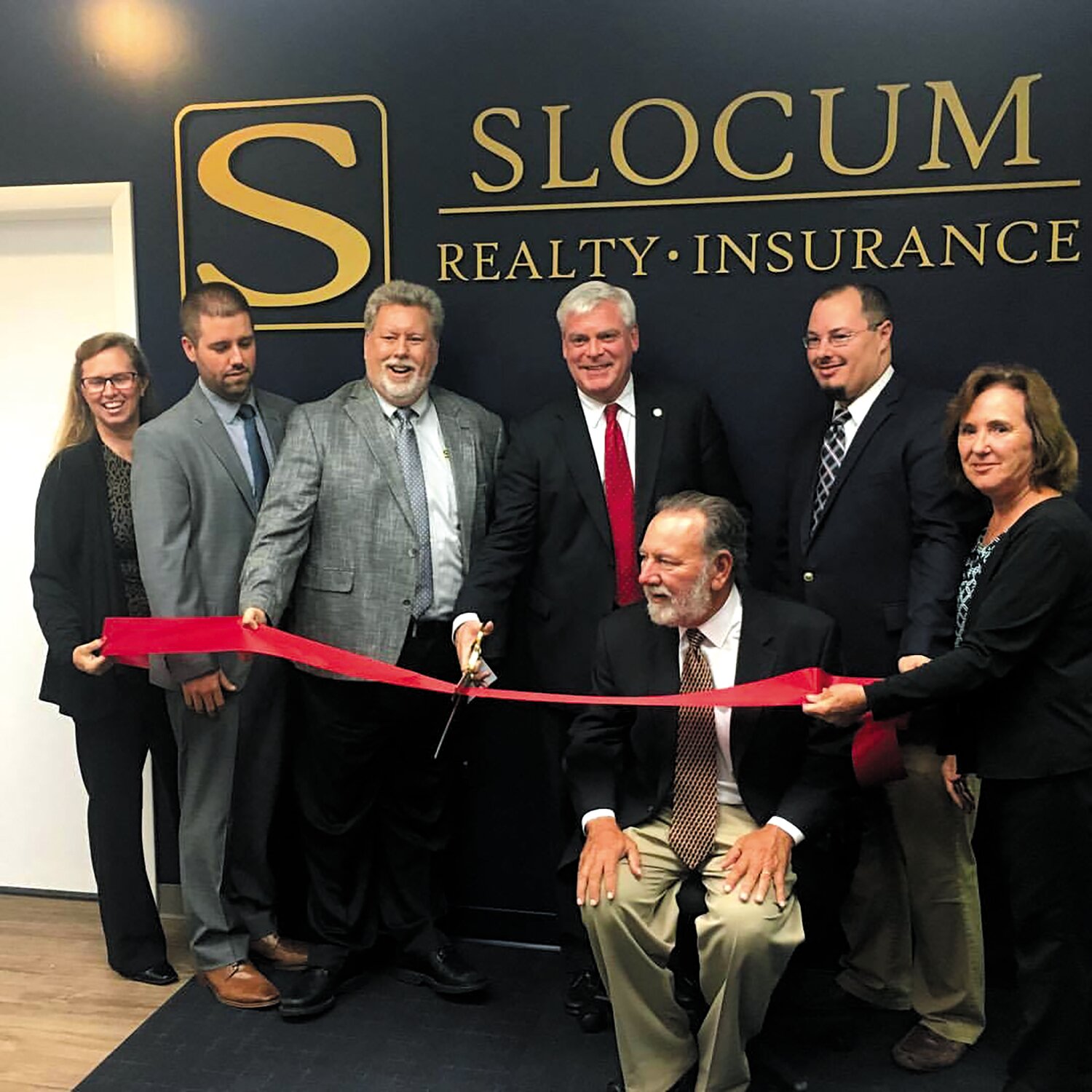 GROWING: From their humble beginnings in 1,100 sq ft on Greenwich Ave. to cutting the ribbon on their new 5,000 sq ft office on Centerville Road in , the family welcomed Mayor Scott Avedisian to do the honors. Pictured from left at the opening in 2017 are Lauren Slocum, Nick Slocum, Phil Slocum, Mayor Scott Avedisian, Bob Slocum, Chris Slocum and Donna Slocum.